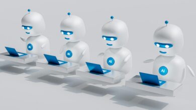 a group of white robots sitting on top of laptops